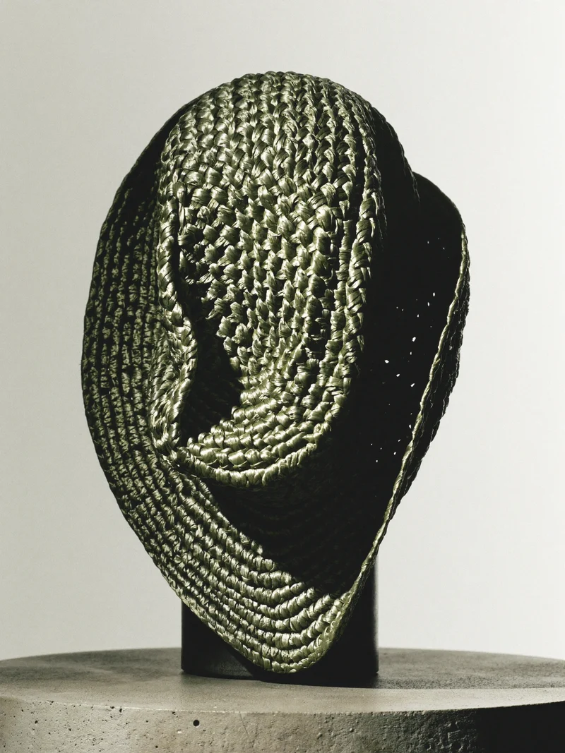 Illustration d'un chapeau de soleil tressé à bord asymétrique.